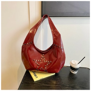 Detailed shot of dark red patent leather bag featuring silver star stud arrangements