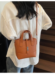 Caramel pebble leather bucket bag with top handles and shoulder strap for women