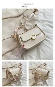 Vue détaillée du sac selle blanc cassé avec poignée en foulard et boucle dorée