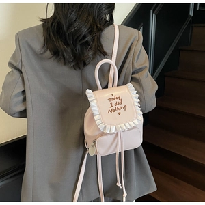 Pink leather backpack featuring a white ruffled trim and Today I did Nothing printed text