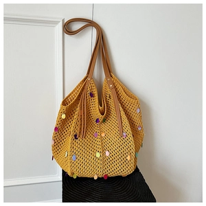 Close-up of yellow knit tote bag featuring colorful sequins and brown leather straps