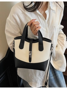 Contrast color leather bucket bag with silver twist lock and adjustable shoulder strap