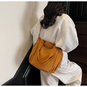 Detail view of large amber nylon tote bag with side drawstring and adjustable strap