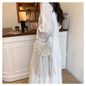 Detailed mesh weaving and wooden bead accents on a bohemian fringe handbag for women