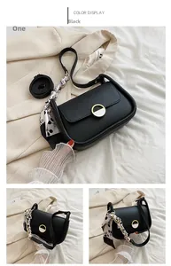 Détail du sac selle noir avec fermoir doré et accessoire de foulard en soie décoratif