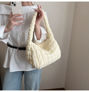 Detail view of a cream quilted cloud bag with hobo design and zipper closure