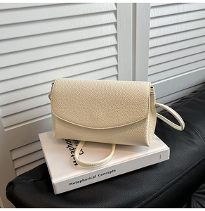 Détail du sac à bandoulière en cuir grainé blanc crème avec rabat arc et texture