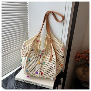Detail of knit crochet tote bag featuring colorful sequin accents and brown leather straps