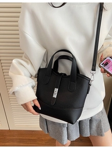 Minimalist black pebble leather bucket bag with silver hardware and adjustable strap