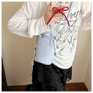 Vue détaillée du sac seau bleu clair en cuir grainé avec une doublure à cordon