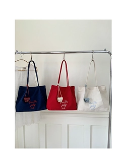 Detailed embroidery on canvas tote bags in navy blue, red, and beige colors