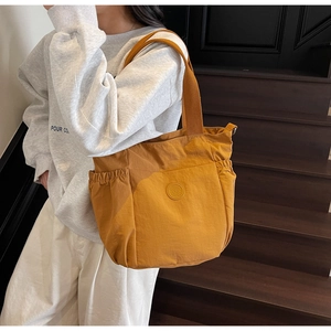 Close-up of yellow casual tote bag with side pockets and a soft nylon texture
