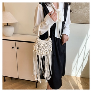 Detail of bohemian handmade woven bag with cotton fringes and wooden beads texture
