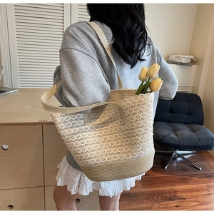 Détail du sac cabas tissé avec coutures en dentelle blanche et bandoulière robuste