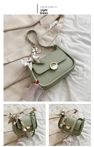 Détails du sac selle vert clair avec foulard en soie et boucle métallique dorée