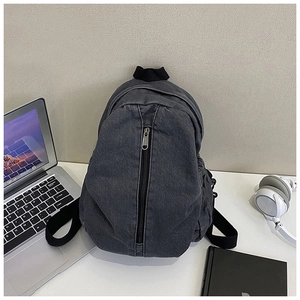 Détail du sac à dos en denim gris foncé avec fermeture éclair verticale et texture du tissu