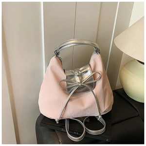 Detailed close-up of pink nylon tote with silver handles and ribbon bow on display