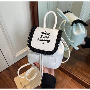 Close-up of white mini backpack with black ruffle trim and 'Today I did Nothing' text detail