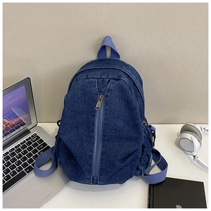 Détail du sac à dos en jean bleu avec sangles violettes dans un décor de bureau réaliste