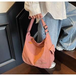 Dettaglio della borsa tote in tela rosa con tasca laterale e tracolla regolabile