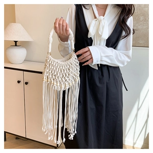 Detail of bohemian cream woven bag featuring intricate tassels and natural wood beads