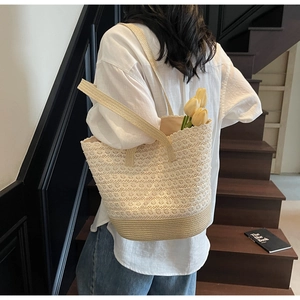 Vue détaillée du motif en dentelle crochetée et de la paille tressée du grand sac cabas