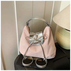 Detail of pink nylon tote with silver bow and metallic accents in a home setting