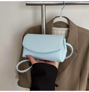 Sac bandoulière bleu clair à texture grainée présenté dans un style de vie décontracté