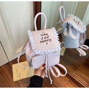 Detail of light pink mini backpack with embroidered text and white frill trim