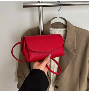 Détail du petit sac à bandoulière en cuir grainé rouge avec fermeture à rabat