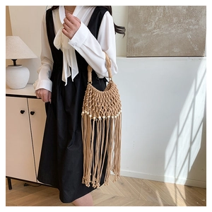 Detail of bohemian woven handbag with white beads and long fringe tassels