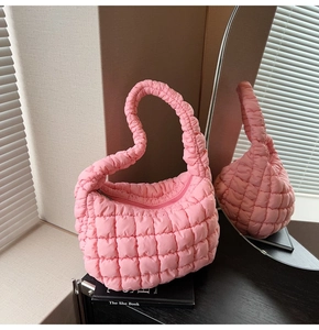 Detail of pink quilted puffer bag showing soft texture and crescent moon design