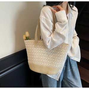 Détail du grand sac cabas tressé avec épissure de dentelle florale et base en paille