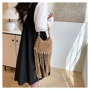 Detail of bohemian macramé handbag with wooden beads and long tassels on white background