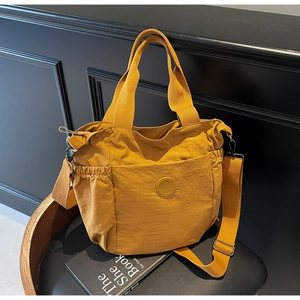 Detailed view of ginger yellow canvas tote bag with drawstring side pockets and wide straps