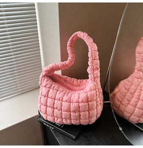 Detalle de bolso acolchado rosa con un diseño exclusivo de asa en forma de corazón chic