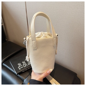 Detail of off-white leather bucket bag with pebble texture and drawstring inner pouch