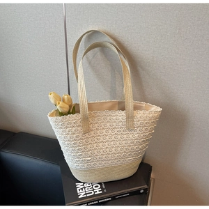 Détails de la dentelle crochetée d'un sac cabas tissé beige avec larges anses en tissu