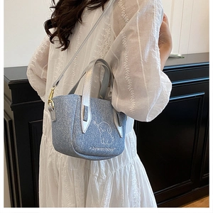 Detail of light blue glitter crossbody bag with cute dog sketch and silver handle