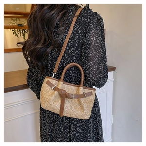 Detail of woven straw shoulder bag with brown leather straps on a polka dot dress