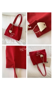 Detailed embroidery of white script on high-density red canvas tote bag with mini pouch