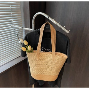 Gros plan détaillé sur la texture tissée ajourée de ce grand sac cabas en paille