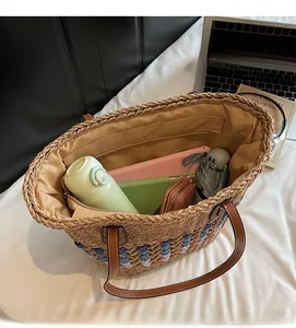 Vue de dessus du grand sac cabas en paille montrant un intérieur spacieux avec des objets