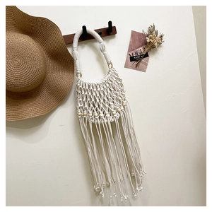 Detail showing white macrame weave patterns with wooden beads and long fringe accents