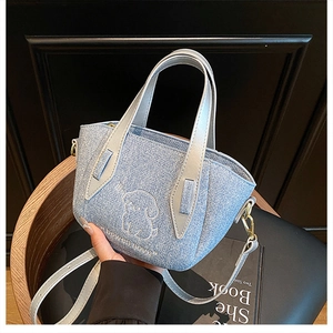 Detail of glitter denim tote bag featuring dog embroidery and adjustable shoulder strap
