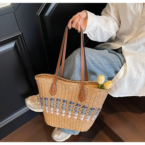 Détail du sac cabas en paille tressée avec accents lavande et anse en cuir marron