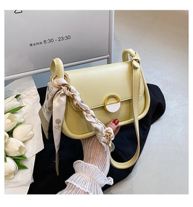 Détail du sac selle crème avec bandoulière en foulard de soie et fermoir métallique