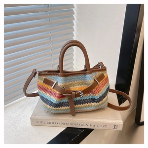 Close-up of bohemian woven bag with colorful wave patterns and brown leather straps