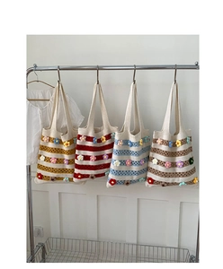 Detailed display of four striped knitted tote bags with colorful crochet flower decorations