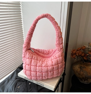 Detail of pink quilted bubble cloud bag with soft pleated handle in natural sunlight